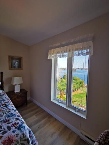 a bedroom with a bed and a large window at 181 Oceanside Inn in Peggy's Cove