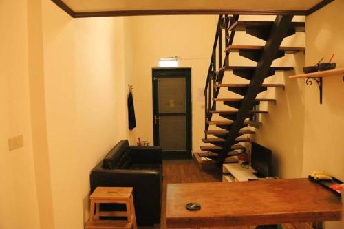a living room with a black spiral staircase at Jiufen Walk Inn 3x3 in Jiufen