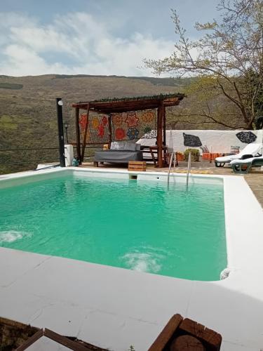 uma grande piscina com um gazebo num quintal em "Casa Ibero" Bubion, Alojamiento Turistico Rural em Bubión