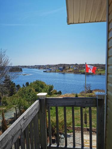 a view of a river from a balcony with a canadian flag at 181 Oceanside Inn in Peggy's Cove
