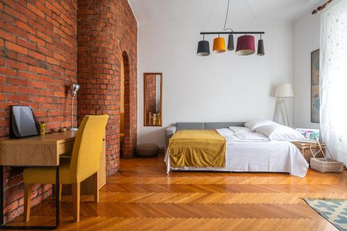 a bedroom with a bed and a desk and a brick wall at Bricks & Bikes in Zagreb