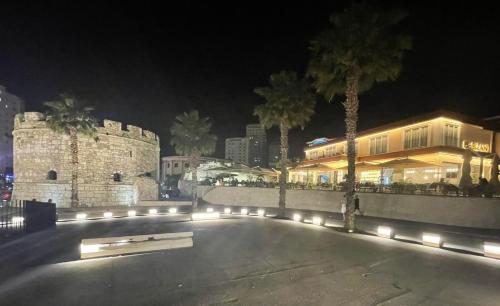 a building with lights on a street at night at Bizant Boutique Hotel & Coffee,Bar in Durrës