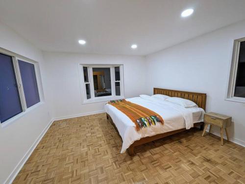 a bedroom with a bed in a room with windows at La Jolla Retreat in San Diego