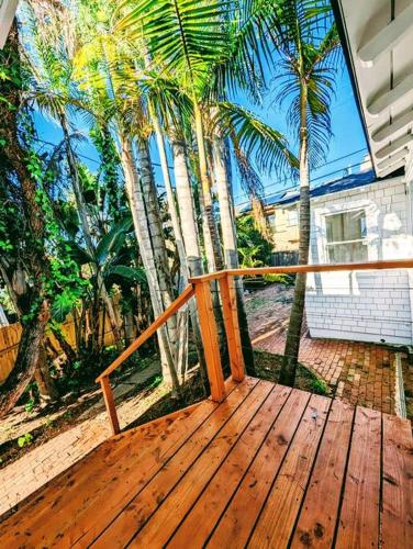 a wooden deck with palm trees in front of a house at La Jolla Retreat in San Diego
