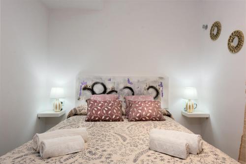 um quarto com uma cama grande e 2 candeeiros em Fuente de la Duquesa em Manilva