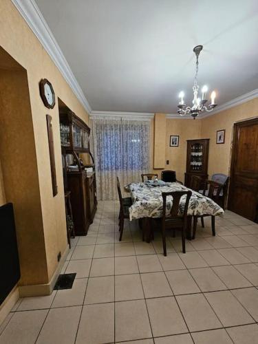 une salle à manger avec une table, des chaises et une horloge dans l'établissement Maison a 10 minutes de Paris SLZ, à Colombes