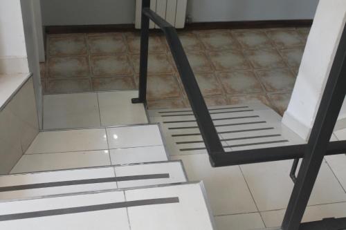 a room with white floors and a black ladder at Hotel Sienna in Mendoza