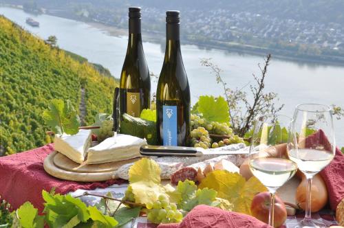 two bottles of wine and cheese on a table with wine glasses at Weinhotel Landsknecht in Sankt Goar