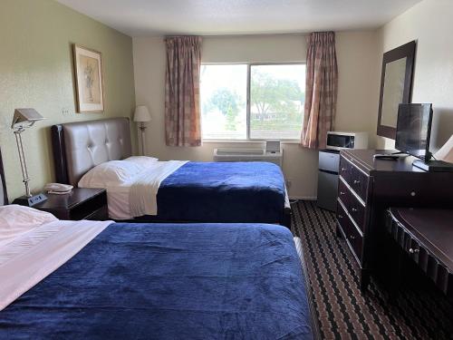 Habitación de hotel con 2 camas y TV en River Walk Inn, en Fort Atkinson