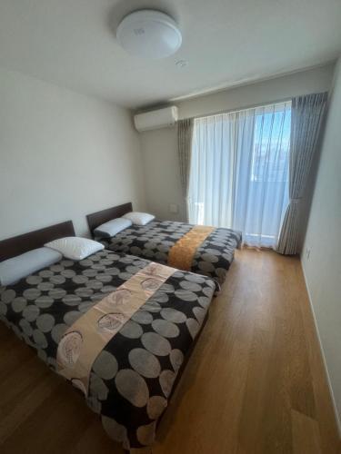 1 Schlafzimmer mit 2 Betten in einem Zimmer in der Unterkunft Residence Saku in Osaka