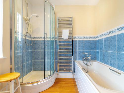 ein Badezimmer mit Badewanne und Glasdusche in der Unterkunft Hillside Cottage in Ambleside