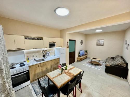 a kitchen and living room with a table and chairs at Shkodra Guest House in Shkodër