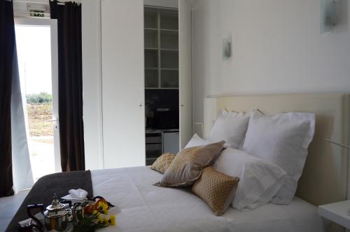 a bedroom with a bed with white sheets and pillows at Entre Vinhas & Mar in Óbidos