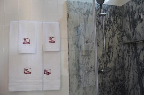 a bathroom with towels with cups on them at Entre Vinhas & Mar in Óbidos