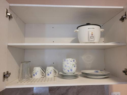 um armário com pratos e um bule de chá em Paradise Comfort em Koror