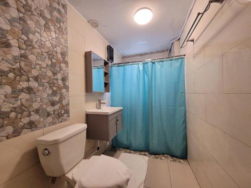 uma casa de banho com um WC e uma cortina de chuveiro azul em Paradise Comfort em Koror