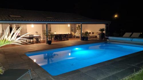 une piscine dans un jardin la nuit dans l'établissement Chez Sophie, à Le Barp