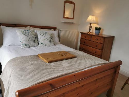 ein Bett mit einem hölzernen Tablett darüber in der Unterkunft Entire house Sheffield s10booking in Stannington