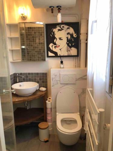 une petite salle de bain avec toilettes et lavabo dans l'établissement Appartement Cosy 2 personnes, à Levallois-Perret