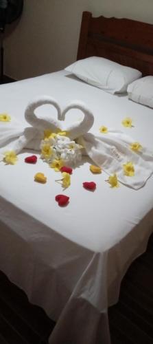 a bed with a heart made out of flowers on it at Village Lagoinha Ceará in Tigre