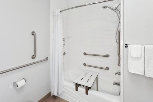 a white bathroom with a shower and a bench at Holiday Inn Express & Suites Carmel North – Westfield, an IHG Hotel in Carmel