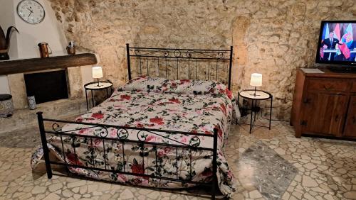 1 dormitorio con 1 cama y TV en una habitación en La casetta di Bianca en Sulmona