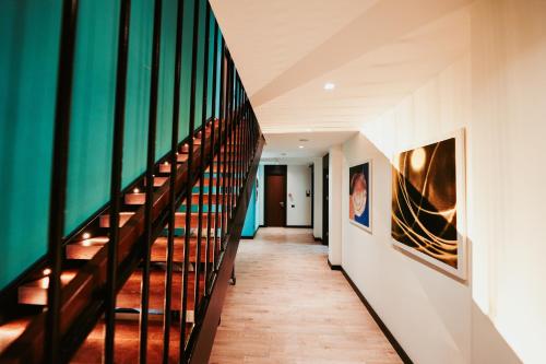a hallway with stairs and paintings on the walls at Palladium Beach Hotel in Dhërmi