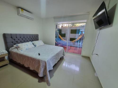 a bedroom with a bed and a flat screen tv at Hermoso Apartamento Cerca a la Playa Puerto Colombia in Puerto Colombia