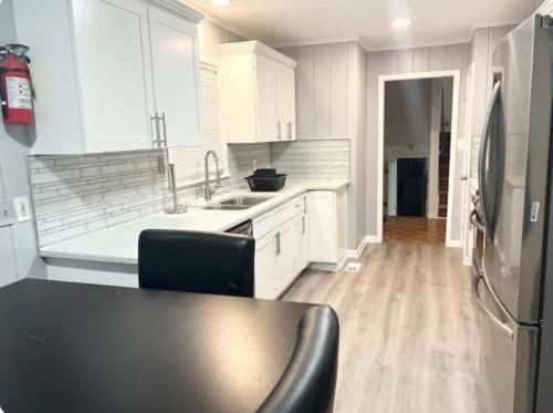 a kitchen with white cabinets and a refrigerator at Queen Suite with Wifi with Hot Tub Room 5 in Atlanta