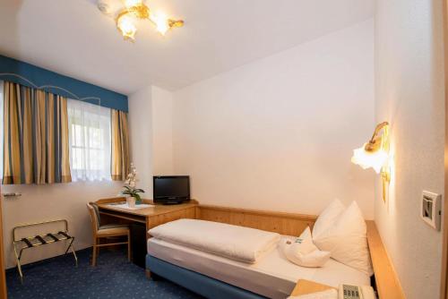 a hotel room with a bed and a desk at Santeshotel in Anterselva di Mezzo