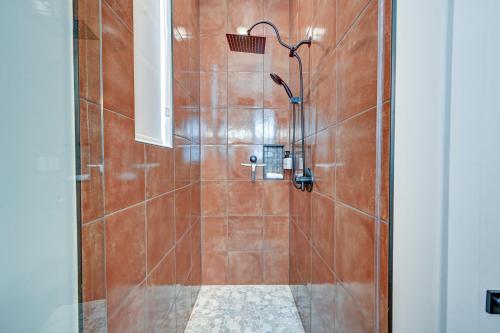 a bathroom with a shower with brown tile at South Main Residences by Surf Hotel in Buena Vista