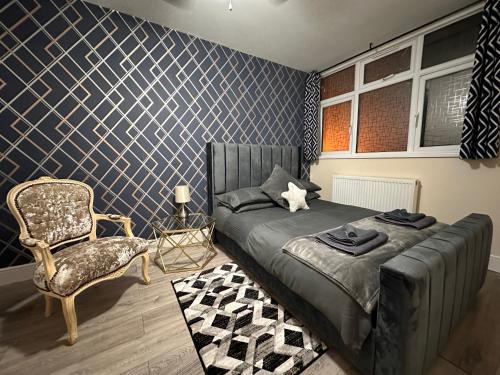 een slaapkamer met een bed en een stoel bij 5 Bed 5 Bath / Brick Lane Central London E1 in Londen