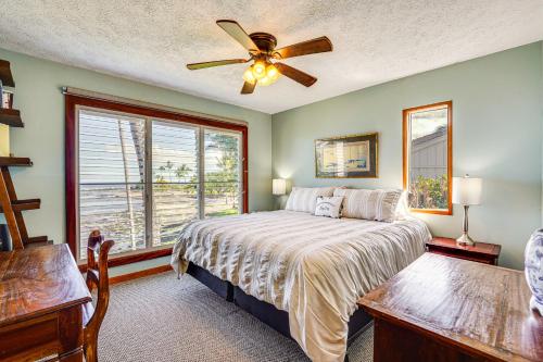 a bedroom with a bed with a ceiling fan and a window at Ultimate Oceanfront Townhome with AandC On Kona Coast in Kailua-Kona