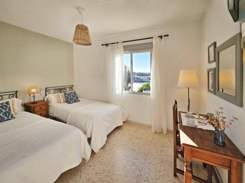 Un dormitorio con dos camas y una ventana. en Los Molinos, en Sanlúcar de Guadiana