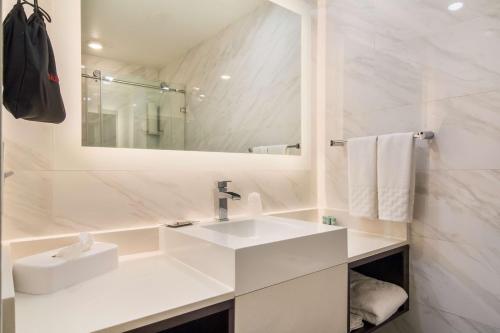 a white bathroom with a sink and a mirror at Best Western Historic Bayfront in Saint Augustine