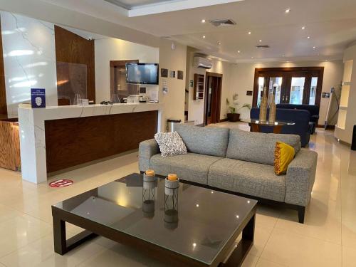 ein Wohnzimmer mit einem Sofa und einem Couchtisch in der Unterkunft Best Western Plus Chihuahua Aeropuerto in Chihuahua