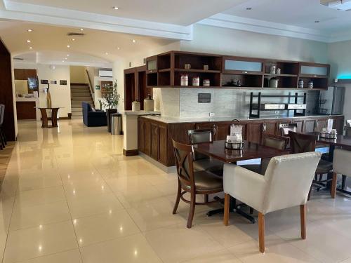 a kitchen and dining room with a table and chairs at Best Western Plus Chihuahua Aeropuerto in Chihuahua