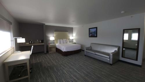 a hotel room with a bed and a chair at West Valley Inn in West Valley City