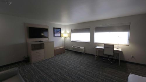 an empty room with a desk and a television at West Valley Inn in West Valley City