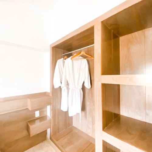 a closet with a white robe hanging in it at Hotel Lujan in Piriápolis
