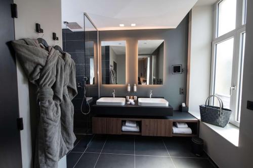 a bathroom with two sinks and a large mirror at Best Western Premier Le Chapitre Hotel and Spa in Remiremont