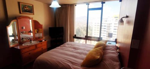 a bedroom with a bed and a mirror and a window at Apartamento en el mejor lugar frente a Embajada de Estados Unidos in La Paz