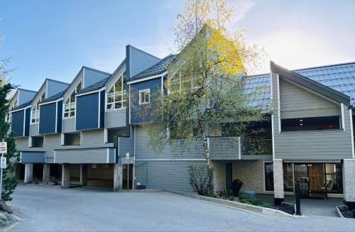 a building with blue siding next to a parking lot at Amazing Views 2 BR/2 BA Ski In Ski Out Condo in Whistler
