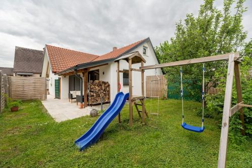 a playground with a slide in the yard of a house at Idyllic holiday home - relaxation place in Leibnitz