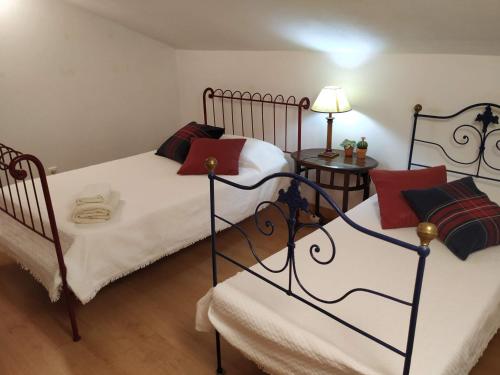 Un dormitorio con dos camas individuales y una lámpara. en Monte da Bela Vista, Colos, en Colos