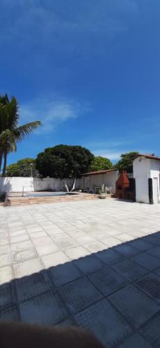 um grande pátio com palmeiras e um edifício em Casa Duplex na Praia de Catuama em Ponta do Funil