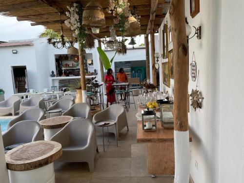 um restaurante com mesas e cadeiras e um bar em Ossoma House em Luanda
