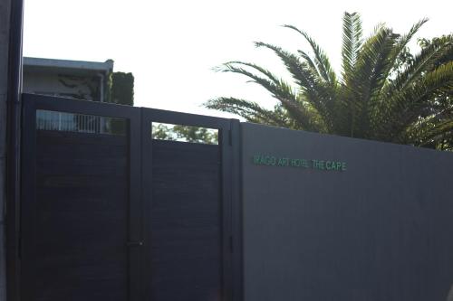 a gate in front of a building with a palm tree at ＩＲＡＧＯ　ＡＲＴ　 ＨＯＴＥＬ 　THECAPE in Irago