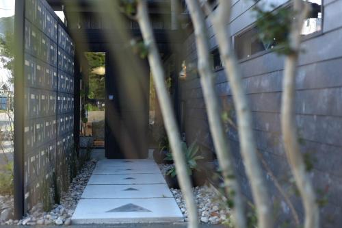 a walkway leading into a building with plants at ＩＲＡＧＯ　ＡＲＴ　 ＨＯＴＥＬ 　THECAPE in Irago