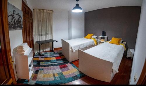 a room with two beds and a rug at Apartamento A Casa De Silvia in Padrón